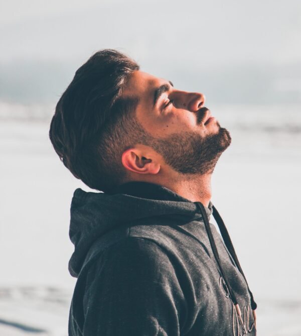 Man looking up toward sunlight with clam and relaxed expression
