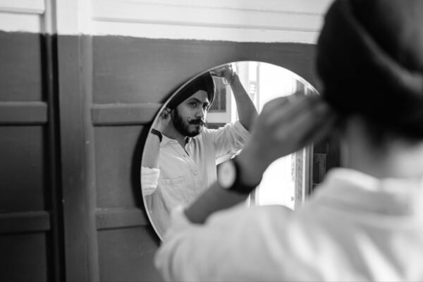Home Man adjusting grooming in mirror with turban