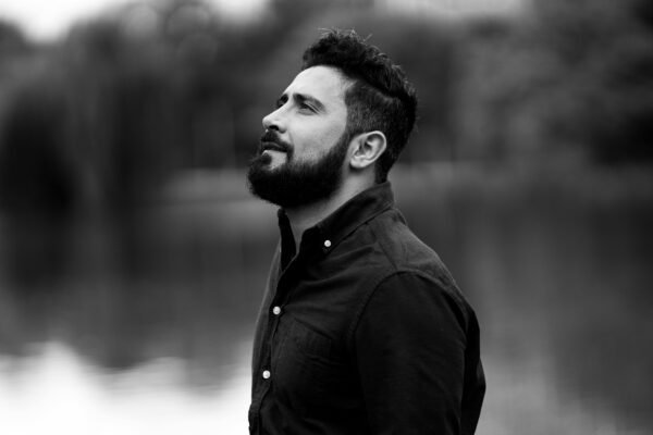 Home Bearded man looking up in black shirt outdoors