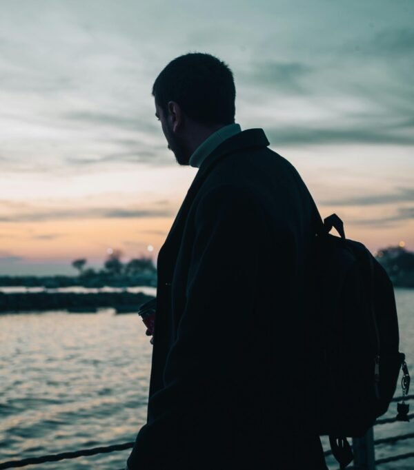 man seen from behind overlooking lake