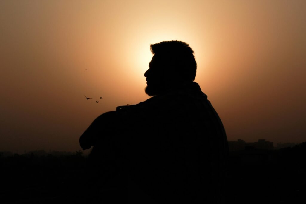 Home man sitting behind sunset